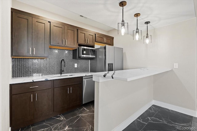 kitchen featuring sink, appliances with stainless steel finishes, dark tile patterned floors, tasteful backsplash, and kitchen peninsula