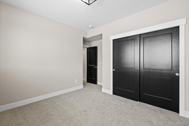 unfurnished bedroom featuring light colored carpet and a closet