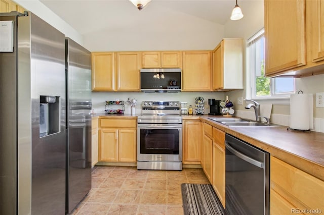 16304 10th St, Mead, CO 80542 - kitchen with stainless steel appliances, light brown cabinetry, a sink, vaulted ceiling, and light countertops