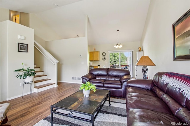 16304 10th St, Mead, CO 80542 - living room featuring wood finished floors, stairs, a chandelier, baseboards, and lofted ceiling
