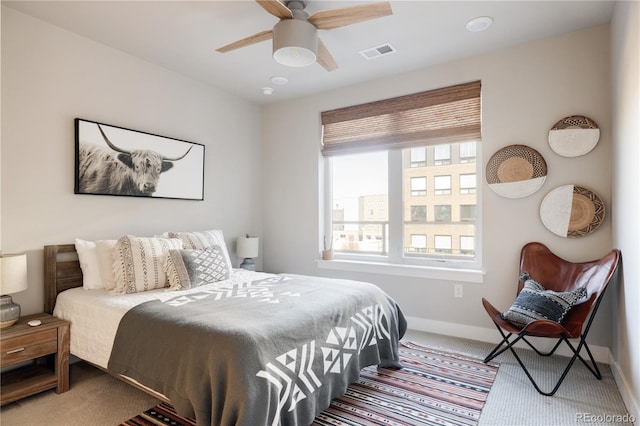 carpeted bedroom with ceiling fan and multiple windows