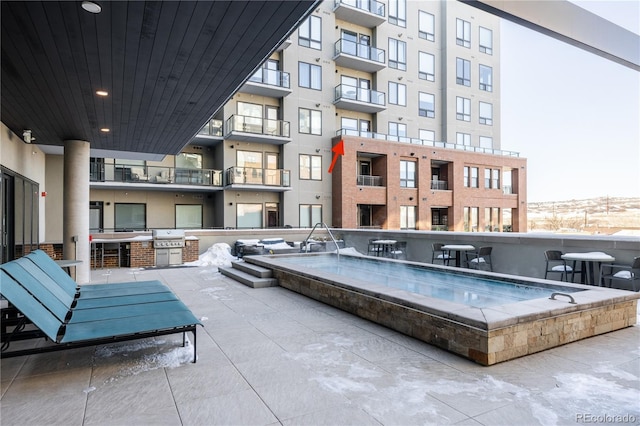 view of swimming pool featuring area for grilling and a jacuzzi