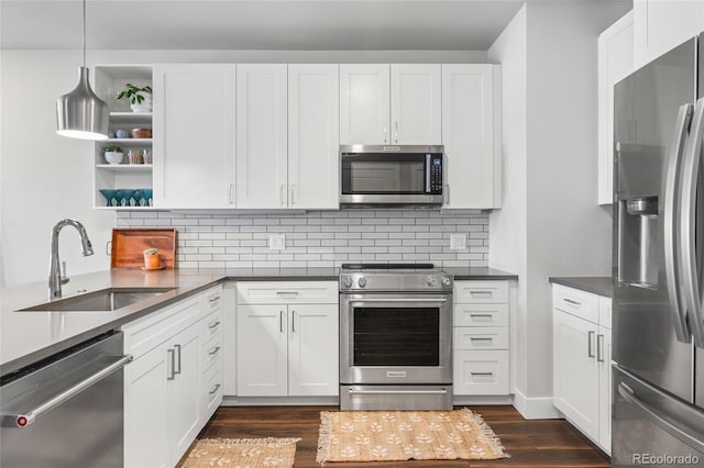 kitchen with white cabinetry, sink, decorative light fixtures, and stainless steel appliances