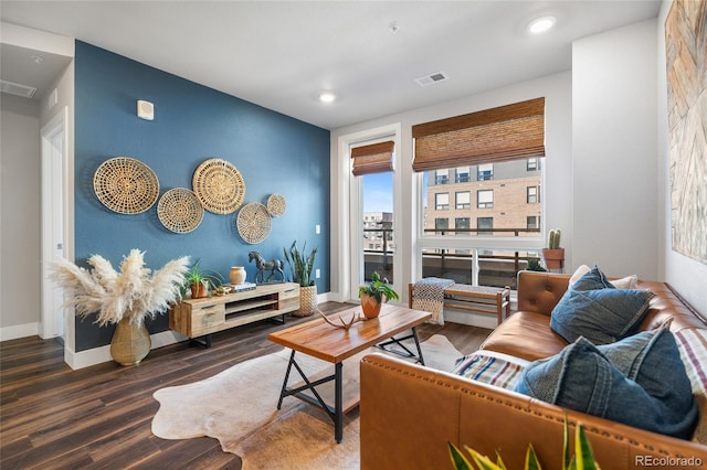 living room with dark wood-type flooring and plenty of natural light