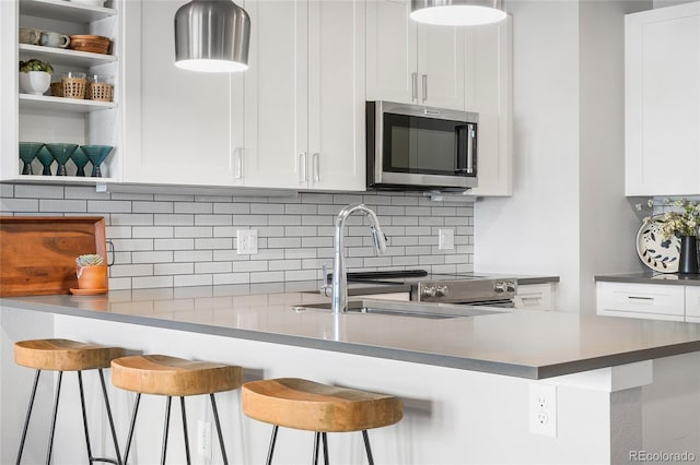 kitchen with white cabinetry, sink, and a kitchen breakfast bar