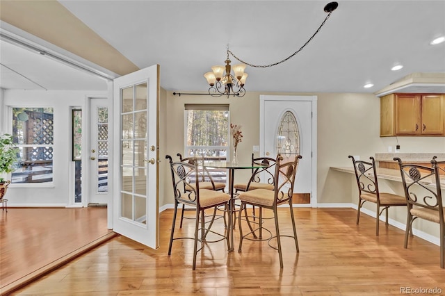 dining area featuring recessed lighting, baseboards, light wood finished floors, and an inviting chandelier