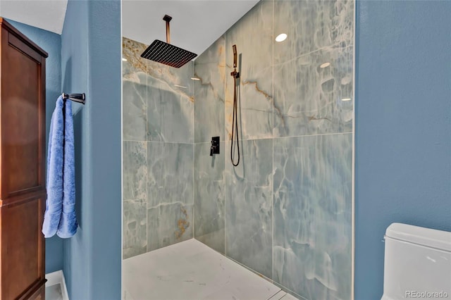 bathroom with toilet and a marble finish shower