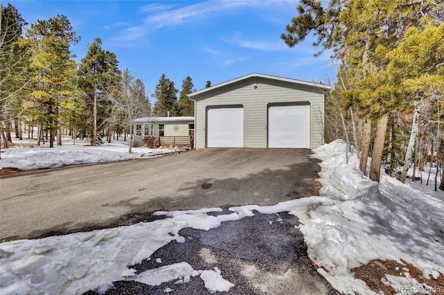 snow covered garage featuring a garage