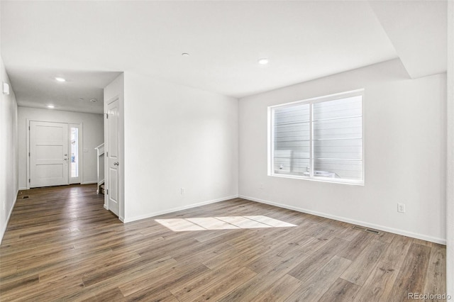 spare room featuring recessed lighting, visible vents, baseboards, and wood finished floors