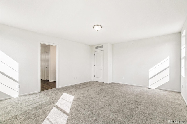 carpeted empty room with visible vents and baseboards