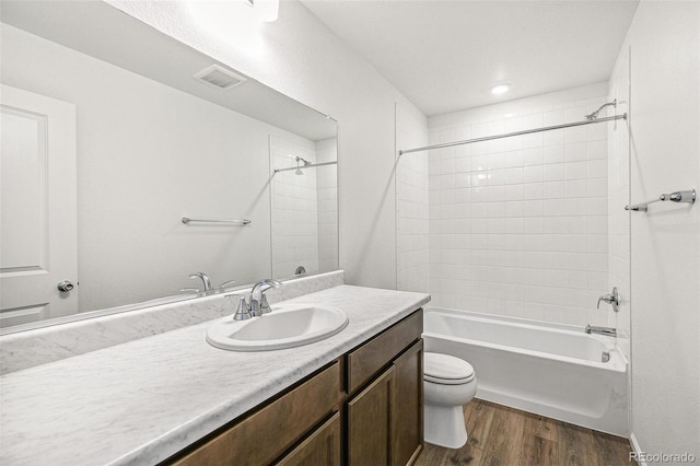 full bath with shower / washtub combination, visible vents, toilet, vanity, and wood finished floors