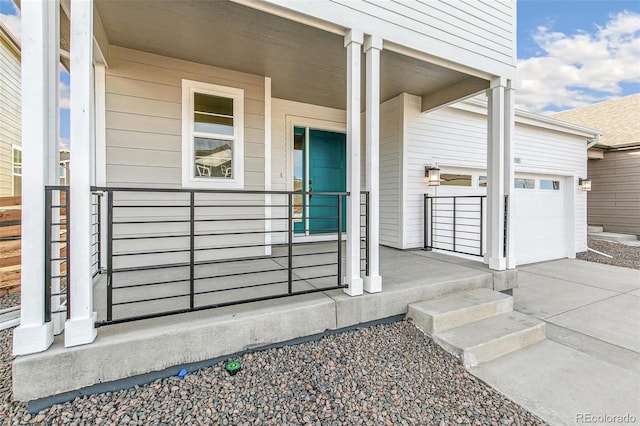 doorway to property with covered porch, driveway, and an attached garage