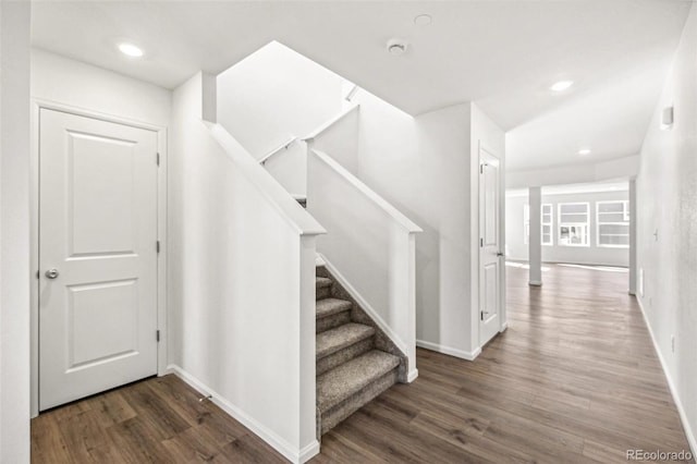 stairway with recessed lighting, wood finished floors, and baseboards