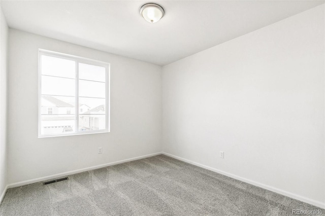 spare room with baseboards, visible vents, and carpet flooring