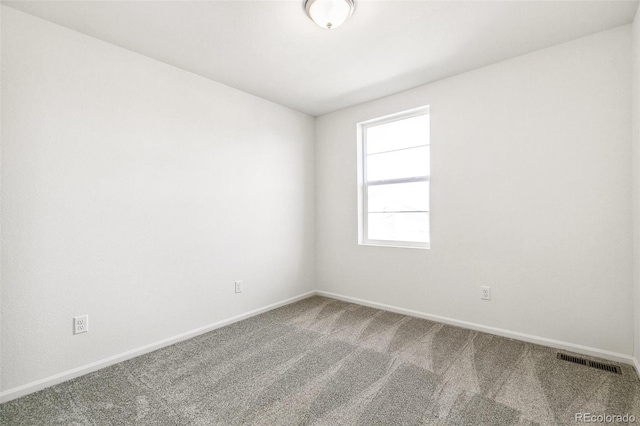 carpeted empty room featuring visible vents and baseboards