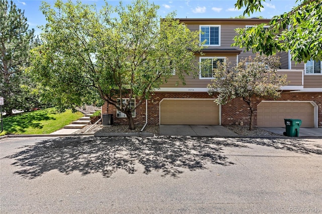 view of front of property with driveway, a garage, and brick siding