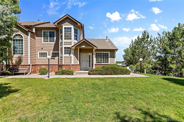 view of front of house featuring brick siding and a front lawn