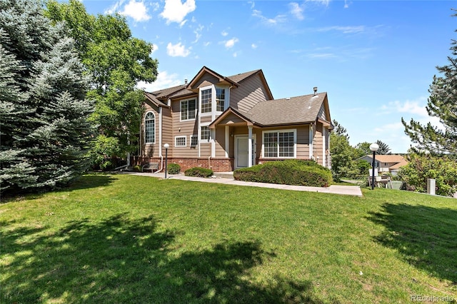 traditional-style house with brick siding and a front lawn