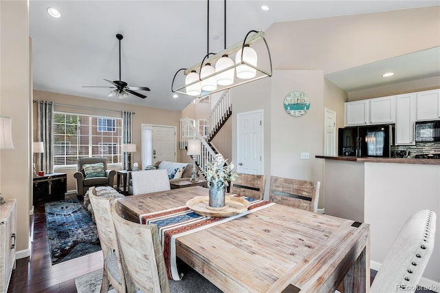 dining room with dark wood finished floors, ceiling fan, stairs, vaulted ceiling, and recessed lighting