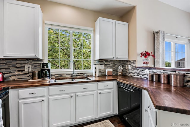 kitchen featuring decorative backsplash, plenty of natural light, wooden counters, and a sink