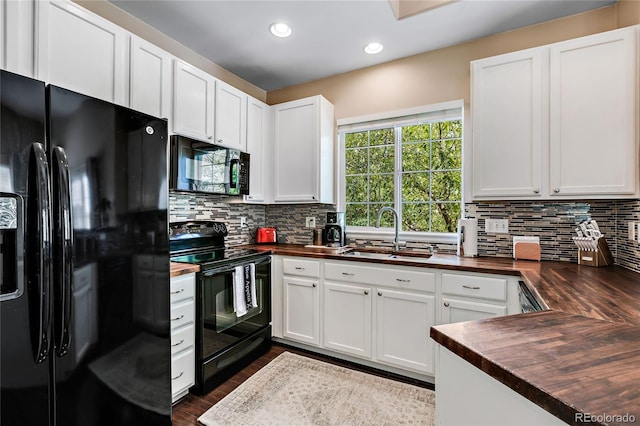 kitchen with black appliances, a sink, wood counters, and decorative backsplash