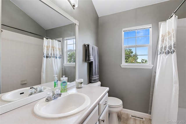 full bath with toilet, visible vents, vanity, and a wealth of natural light