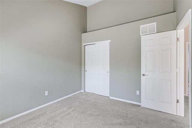 unfurnished bedroom featuring a closet, carpet, visible vents, and baseboards