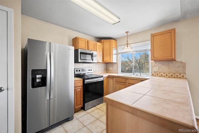 kitchen with decorative light fixtures, decorative backsplash, appliances with stainless steel finishes, and sink