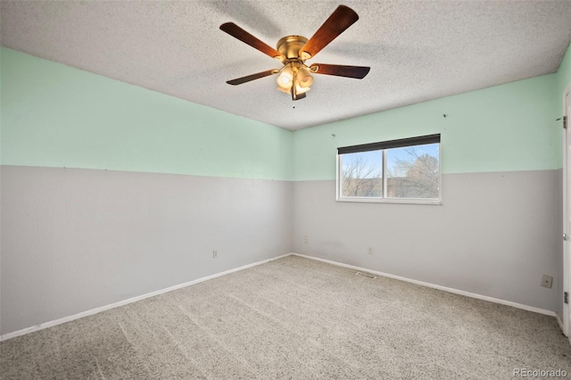 carpeted spare room with ceiling fan and a textured ceiling