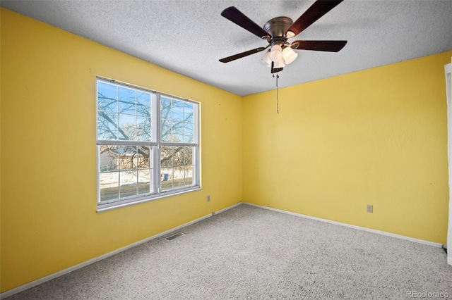 carpeted spare room with a textured ceiling and ceiling fan