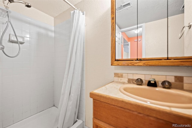 bathroom with backsplash, vanity, a textured ceiling, and a shower with shower curtain