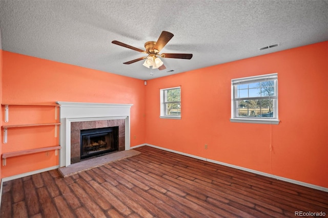 unfurnished living room featuring a textured ceiling, ceiling fan, a fireplace, and hardwood / wood-style flooring