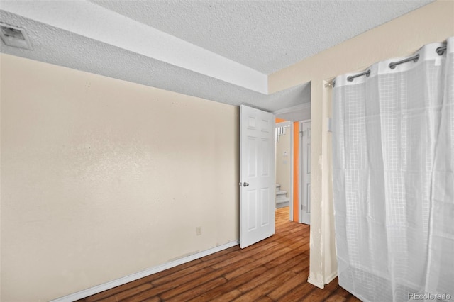 unfurnished bedroom featuring a textured ceiling and hardwood / wood-style flooring