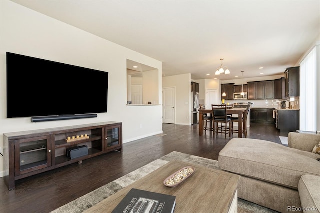 living room with an inviting chandelier, dark wood-style flooring, baseboards, and recessed lighting