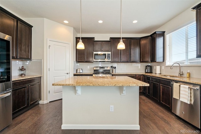 kitchen featuring dark brown cabinetry, appliances with stainless steel finishes, decorative backsplash, and a sink