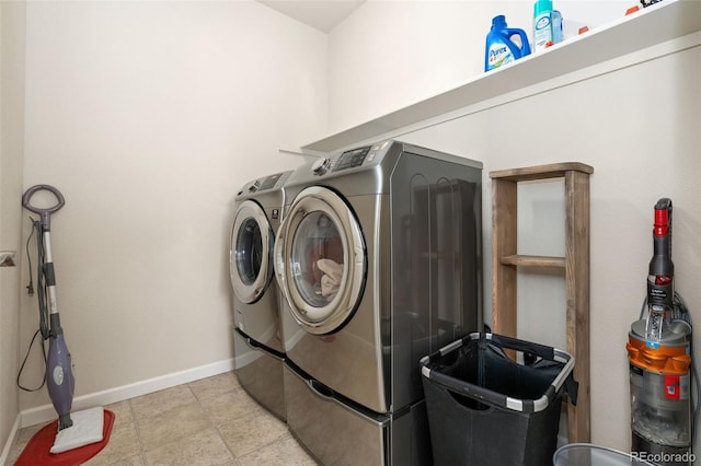 clothes washing area featuring washer and dryer, laundry area, and baseboards