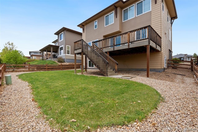 back of property featuring stairway, a deck, a lawn, and a fenced backyard