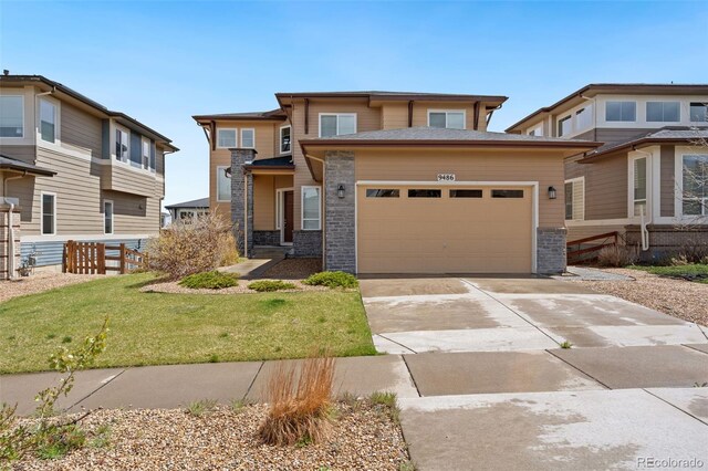 prairie-style home with fence, stone siding, driveway, a garage, and a front lawn