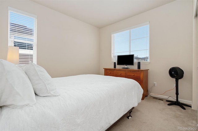 bedroom featuring baseboards, multiple windows, visible vents, and light colored carpet