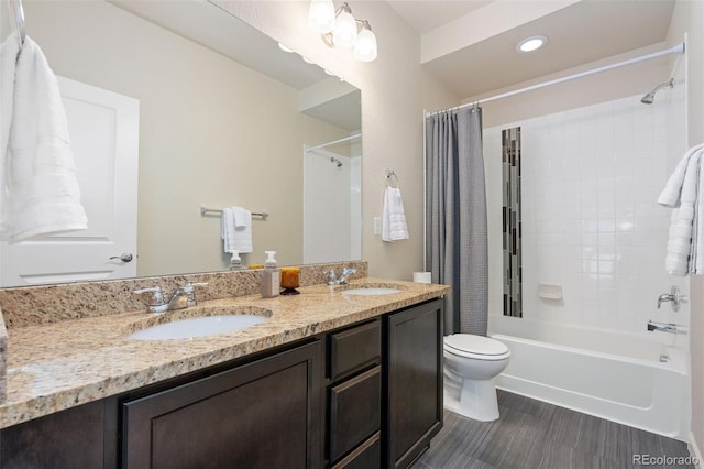 bathroom with a sink, double vanity, toilet, and shower / bath combo