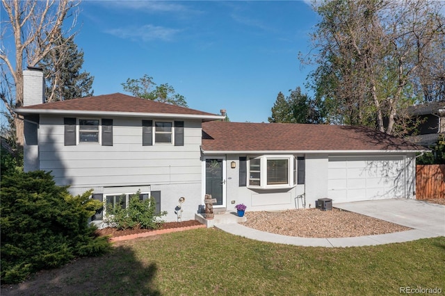 4374 E Peakview Cir, Centennial, CO 80121 - tri-level home with driveway, a chimney, a garage, a front lawn, and roof with shingles