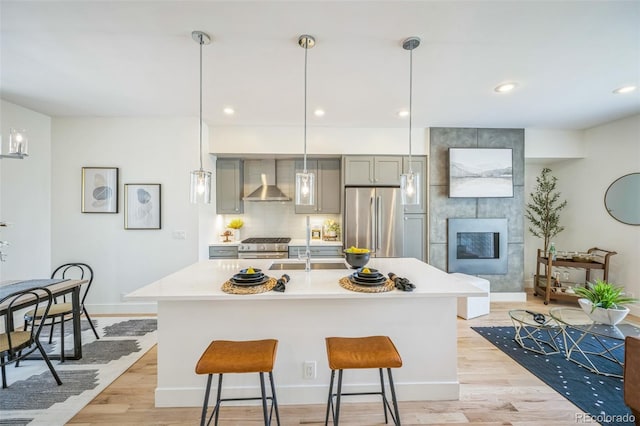 4922 Lowell Blvd Unit 3, Denver, CO 80221 - kitchen with stainless steel appliances, gray cabinets, light countertops, light wood-type flooring, and wall chimney exhaust hood