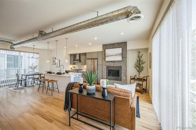 4922 Lowell Blvd Unit 3, Denver, CO 80221 - living area with light wood-type flooring, a tiled fireplace, and recessed lighting