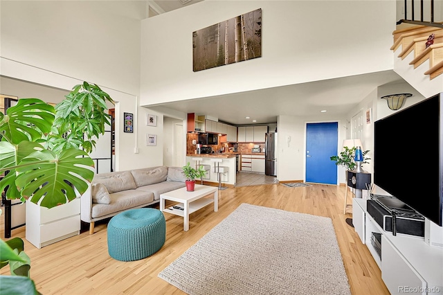 2351 Federal Blvd Unit 401, Denver, CO 80211 - living room with a towering ceiling, light wood-type flooring, and stairs