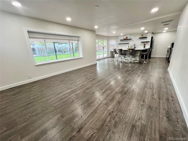 living room featuring dark wood-type flooring and bar