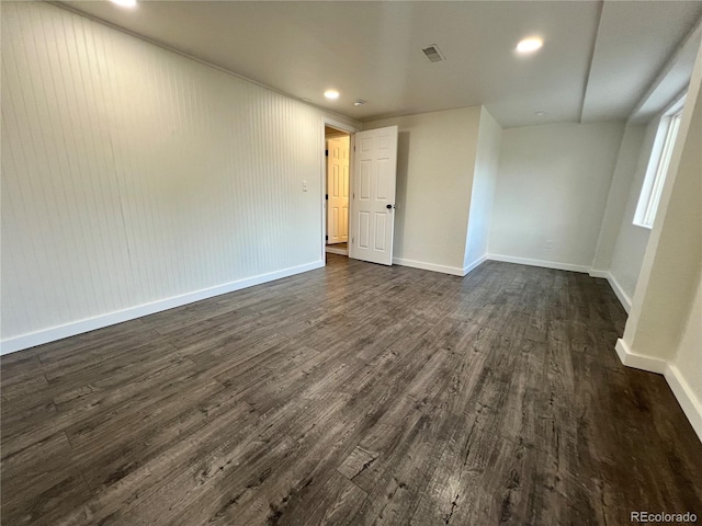 unfurnished room with dark wood-type flooring