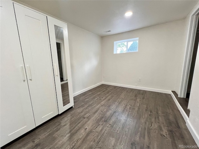 unfurnished bedroom with dark wood-type flooring and a closet