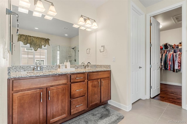 5615 Clover Ridge Cir, Castle Rock, CO 80104 - bathroom with double vanity, a shower stall, tile patterned floors, and a spacious closet