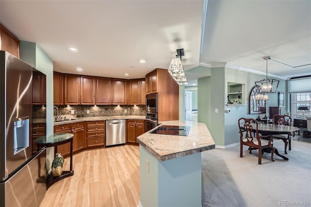 kitchen with pendant lighting, brown cabinets, backsplash, and stainless steel appliances