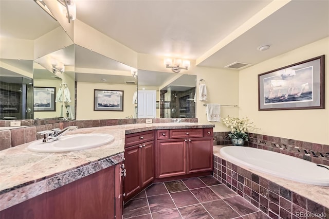 bathroom with visible vents, double vanity, a stall shower, a sink, and a garden tub